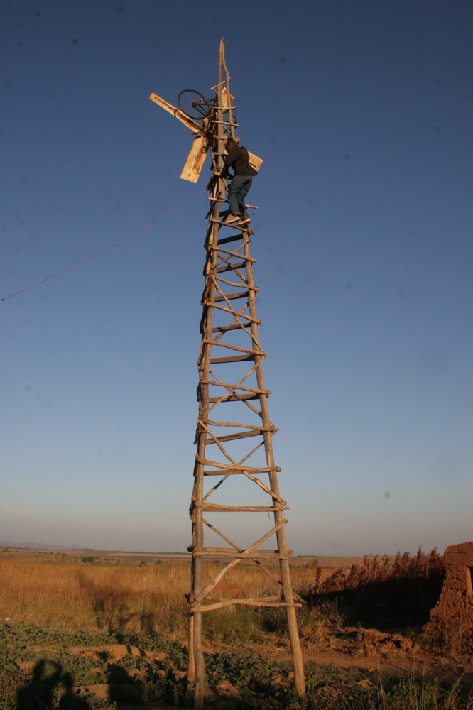 William Kamkwamba climbing the windmill he built in Malawi